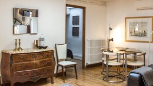 A room with a wooden dresser, a chair, a table with stools, a radiator, and a framed picture on the wall. - Le Grand Croix Baragnon (Toulouse)