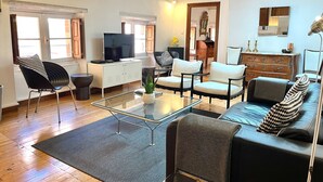 A modern living room with a sofa, armchairs, a coffee table, and a TV. - Le Grand Croix Baragnon (Toulouse)