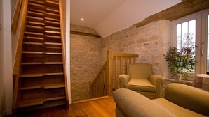 A staircase leading to a loft area with a stone wall and a window with a plant. - Moulin de Cussigny, charming B&B (Corgoloin)
