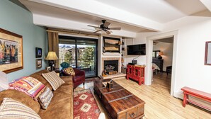 A living room with a brown sofa, a wooden coffee table, a fireplace, and a television. - Central location to Keystone, Breckenridge and Copper Mtn.  (Dillon)
