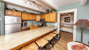 A kitchen with wooden cabinets, a granite countertop, and a built-in bench with stools. - Central location to Keystone, Breckenridge and Copper Mtn.  (Dillon)