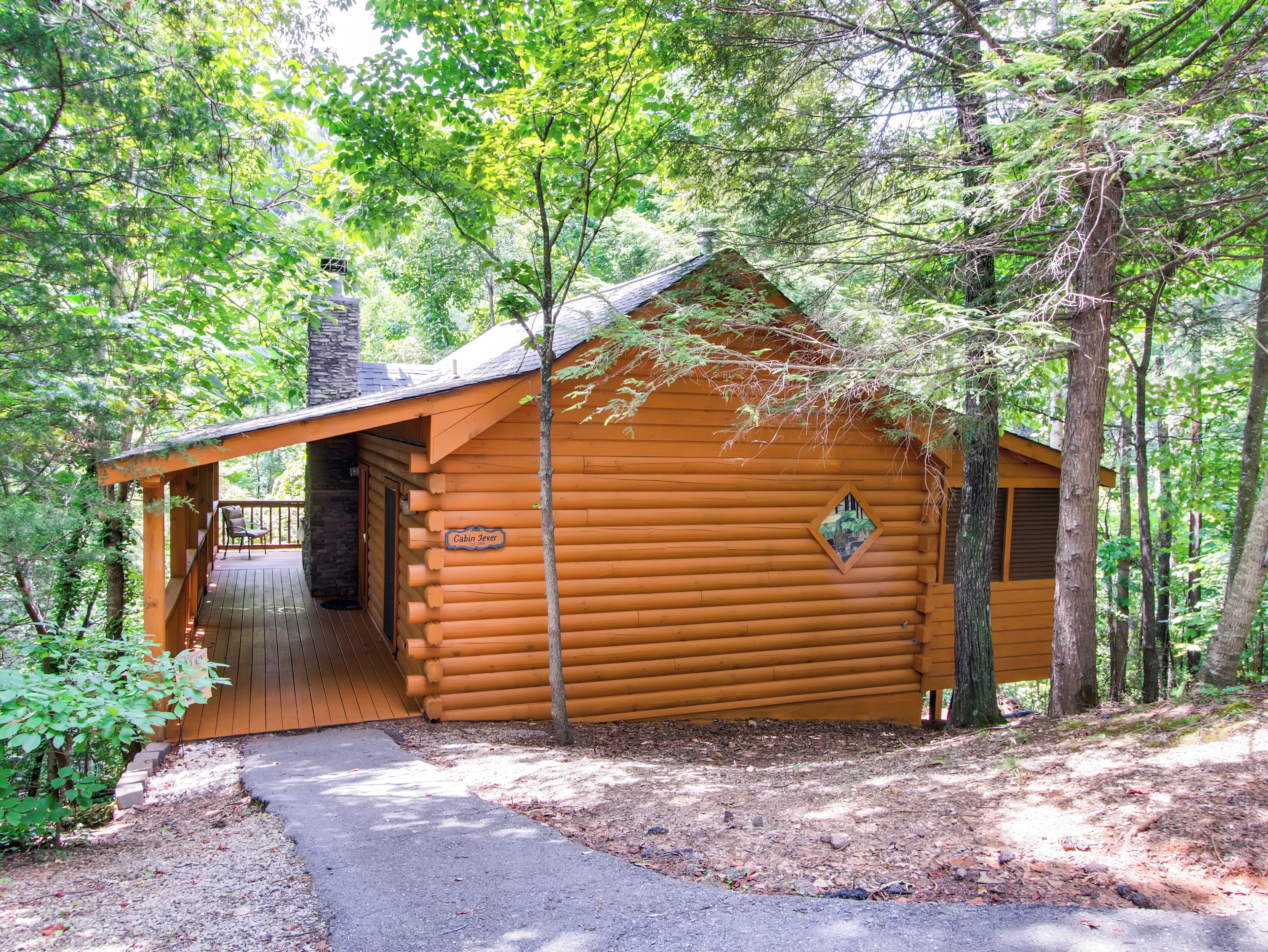 A log cabin with a porch, a door, and a sign that reads "Cabin Jever."