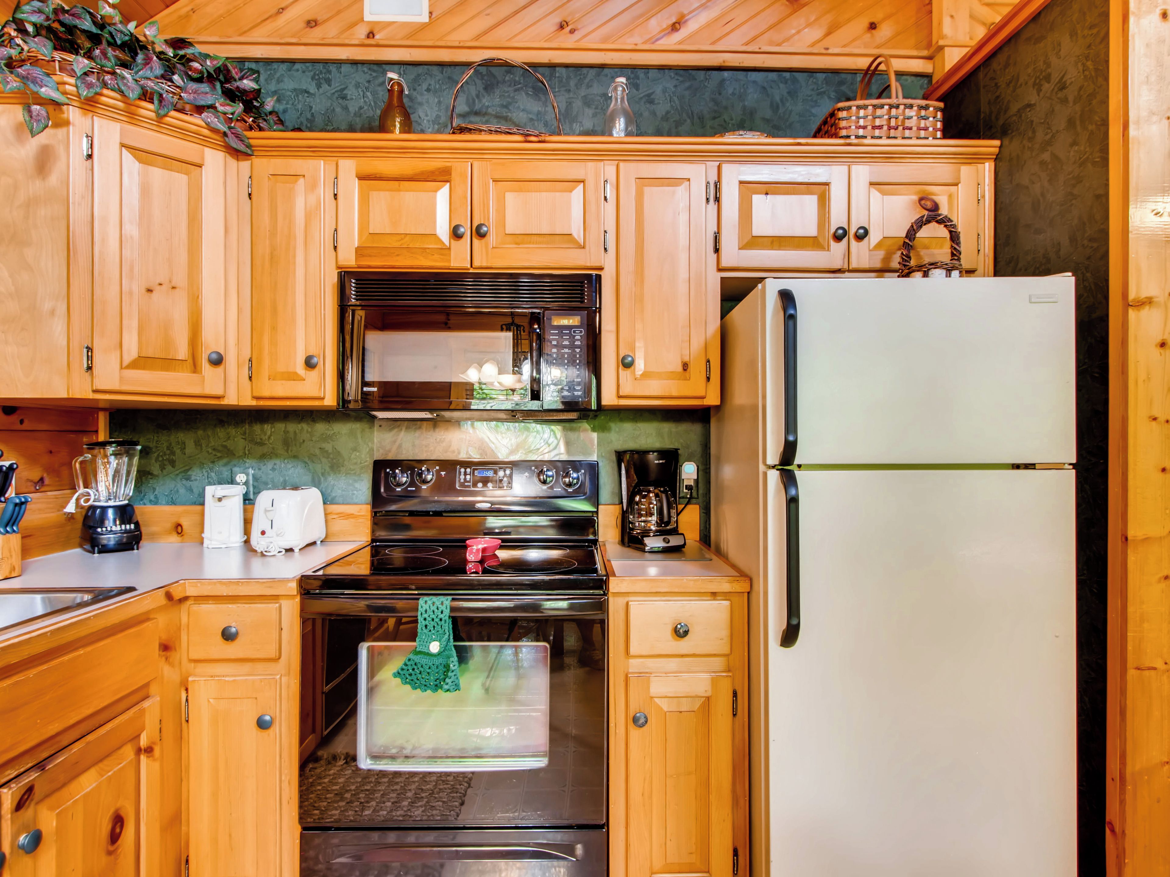 Une cuisine équipée de meubles en bois, d’un four à micro-ondes, d’une cuisinière, d’un réfrigérateur et d’une machine à café.