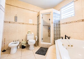 Et badeværelse med toilet, bidet og badekar.