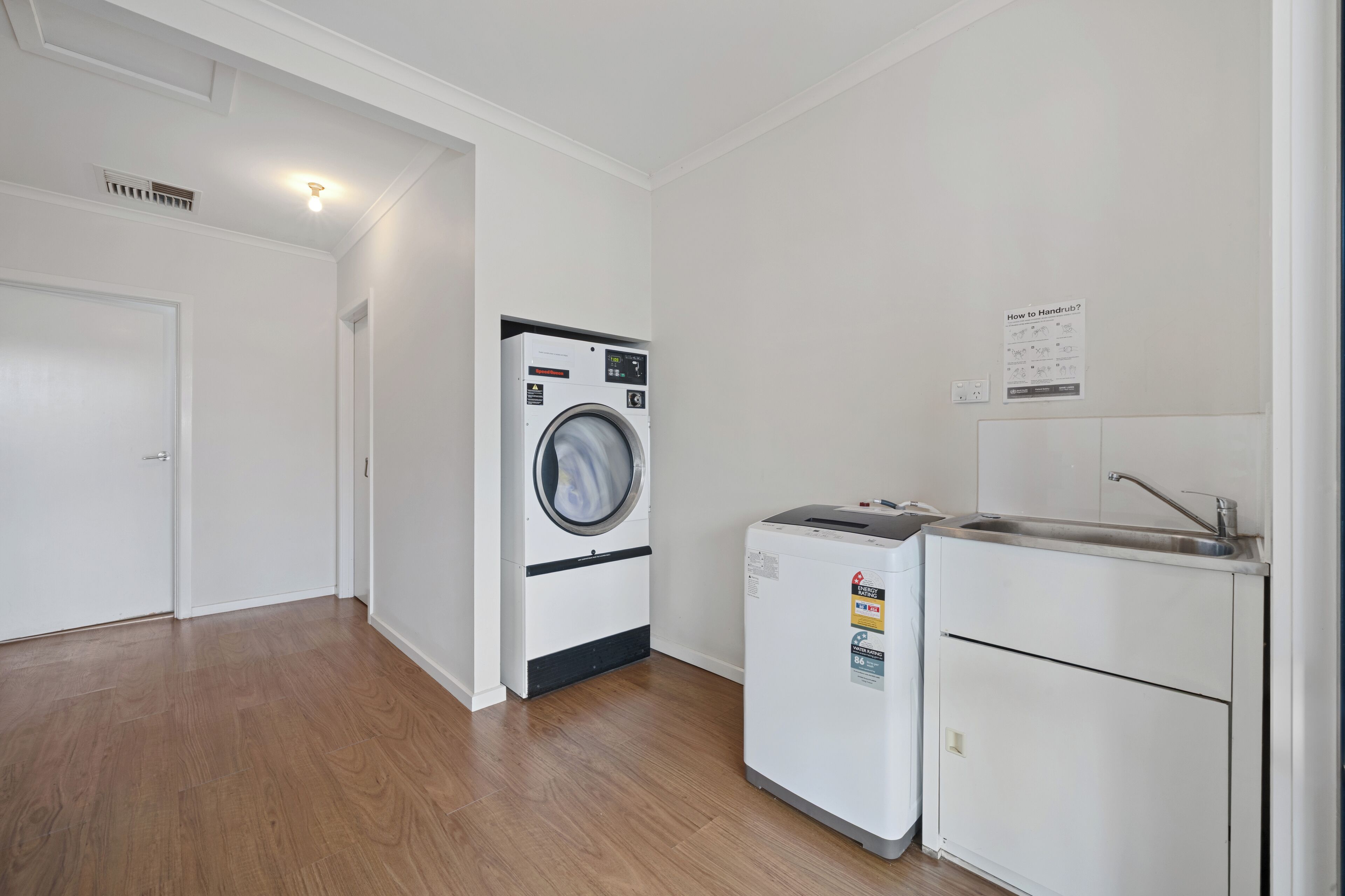 Un cuarto de lavandería con lavadora, secadora y lavabo.