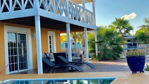 A poolside area with a covered seating area, a pool, and a view of palm trees. - Waterfront Villa, Private Pool & Kayaks (Cooper Jack Bay Settlement)