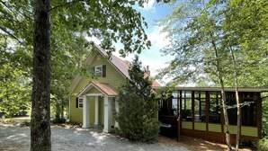 Une maison à deux étages avec un porche couvert et une petite terrasse.