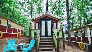 A wooden cabin with a porch and steps leading to a door, surrounded by trees. - #15 Queenie - Gypsy Cottage (Sevierville)