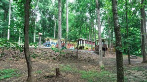 A forested area with colorful cabins. - #15 Queenie - Gypsy Cottage (Sevierville)