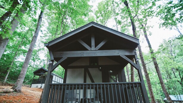 A wooden cabin with a balcony, surrounded by trees. - #11 Mina - *New KitchenTiny Home Cottage (Sevierville)