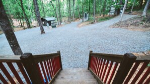 Eine Holztreppe führt zu einem von Bäumen gesäumten Kiesweg.