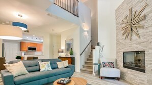 A modern living room with a sofa, coffee table, and a fireplace.
