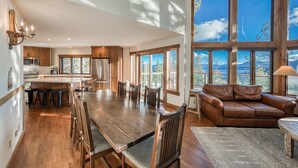A spacious kitchen with wooden cabinets, a large island, and a dining area with a wooden table and chairs. - Tahoe Point of View by Tahoe Getaways - Hot Tub + Sauna + Lake Views + Private Beach (Tahoe City)