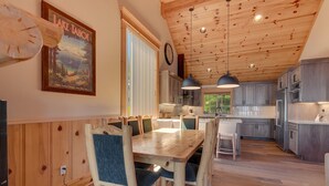 A spacious kitchen with wooden cabinets, a dining area with a wooden table and chairs, and a large window providing natural light.