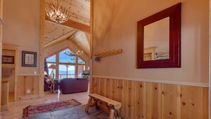 A spacious room with a wooden bench, a large mirror, and a stone-patterned floor.