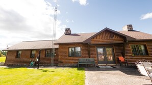En træhytte med veranda, bænk og patio.