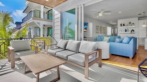Uma sala de estar moderna com sofá, mesa de centro e varanda com guarda-corrimão.