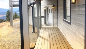 Eine Holzterrasse, die zu einem Haus mit Bergblick führt.