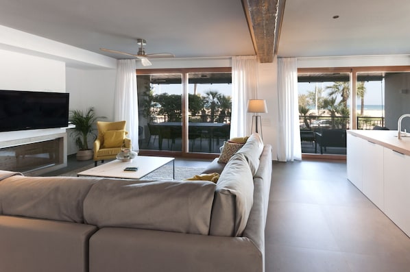 Relax in this spacious living room with a large flat-screen TV, comfortable sofa, and dining area.