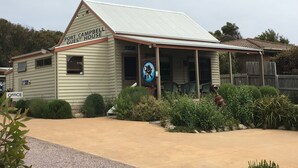 Un edificio de dos plantas con un letrero que dice 'Port Campbell Guest House'.