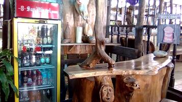 Un rústico espacio de bar con refrigerador San Miguel, adornos de madera y un letrero de 'Welcome'.