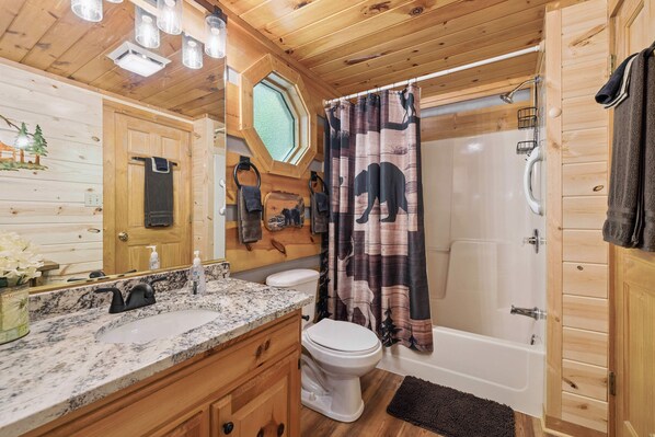 Un baño de cabaña de madera con lavamanos, inodoro y bañera.