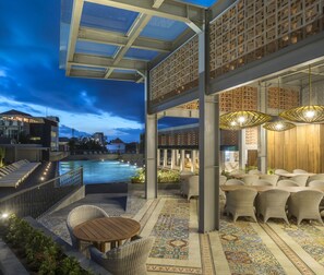 A rooftop pool area with a glass ceiling, outdoor seating, and a patterned floor. - Eastin Ashta Resort Canggu (Canggu)