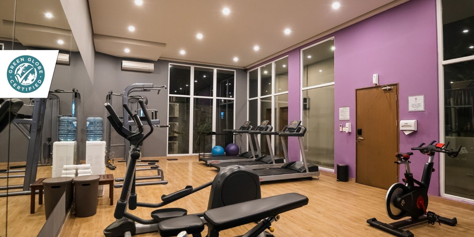 A gym with treadmills, an elliptical, and a stationary bike.