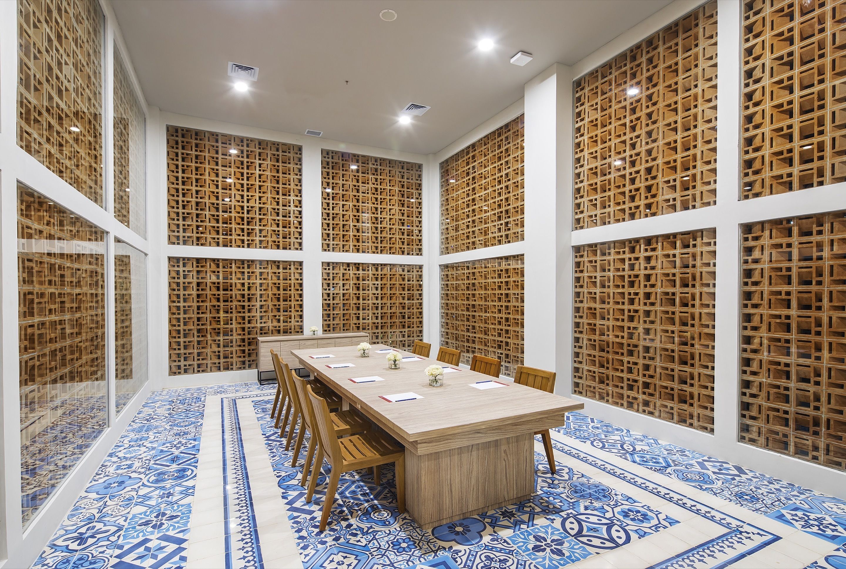 A conference room with a long table, chairs, and a patterned floor.