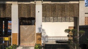 A courtyard with a stone pathway, decorative lattice panels, and a water feature.