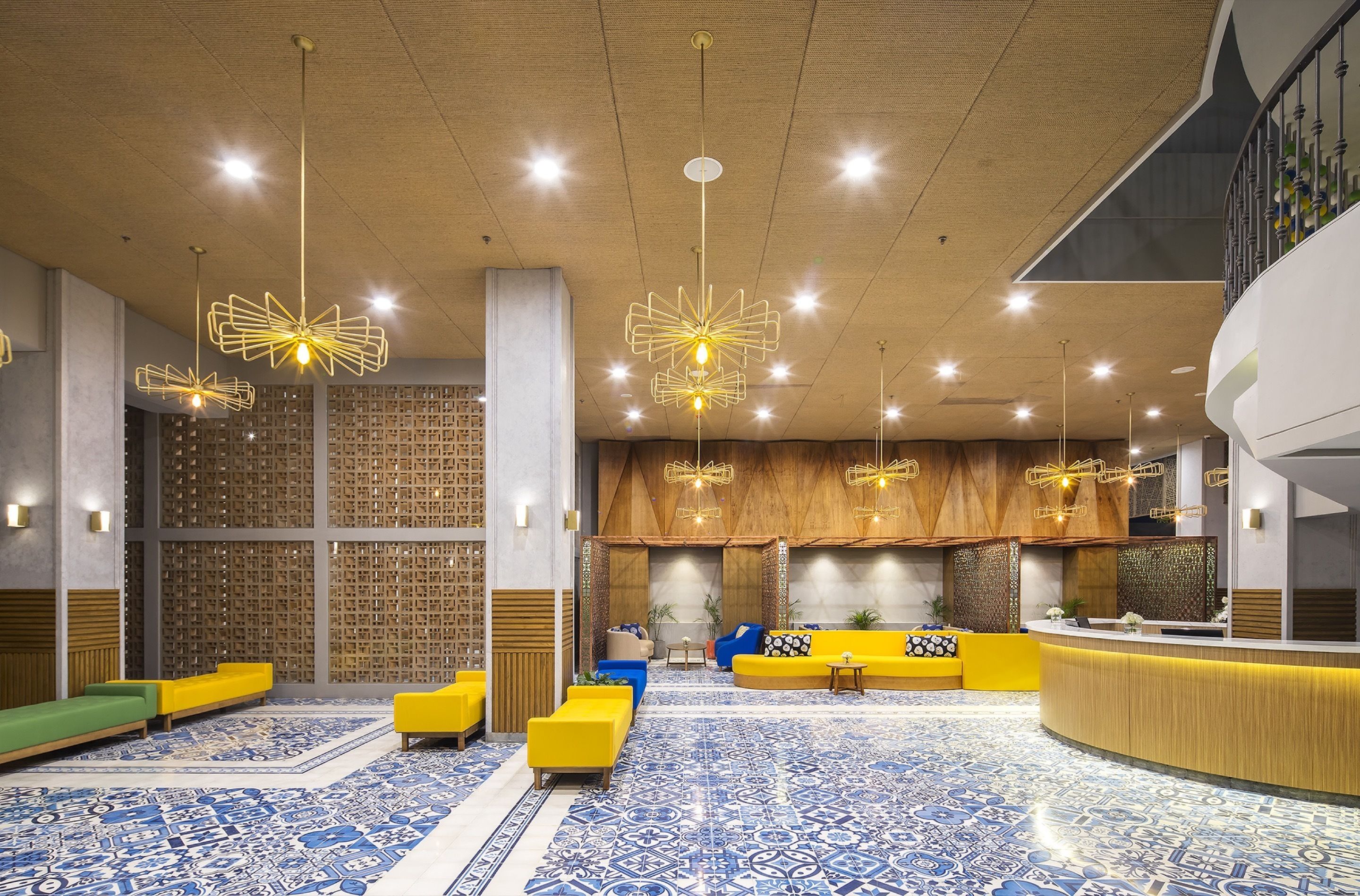 Un hall d’entrée moderne avec un comptoir d’accueil, des espaces de détente et un revêtement de sol à motifs.