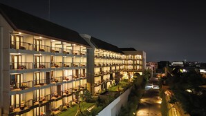 A multi-story hotel with balconies and a well-lit facade.