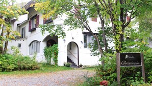A white building with arched windows and a staircase leading to the entrance. - Chalet Christiania (Yamanouchi)