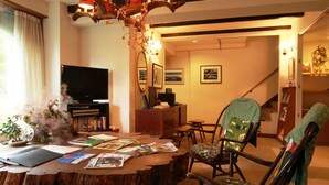 A cozy living room with a wooden coffee table, a television, and a fireplace. - Chalet Christiania (Yamanouchi)