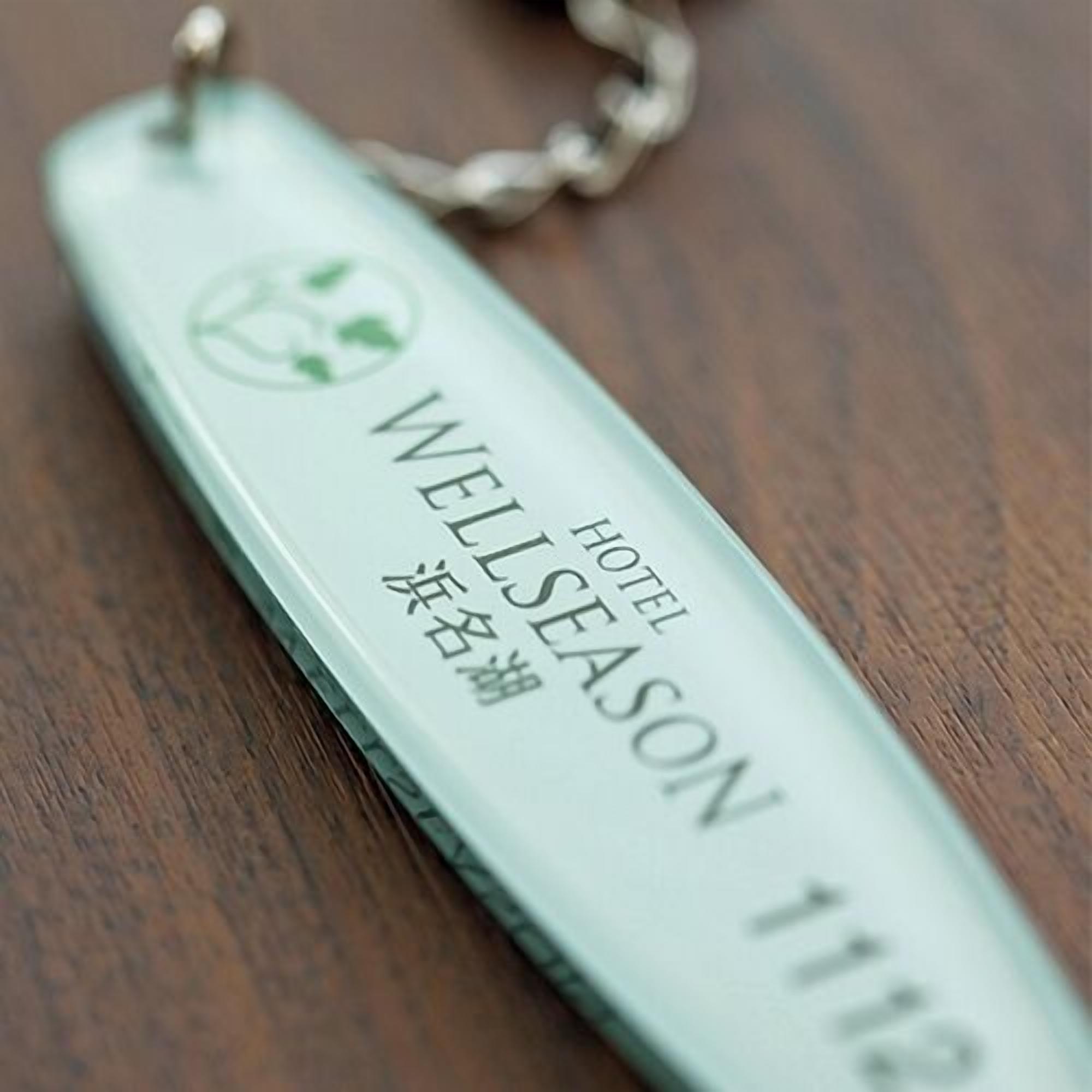 Een hotel sleutelkaart met 'WELLSEASON 111' en Japanse karakters.
