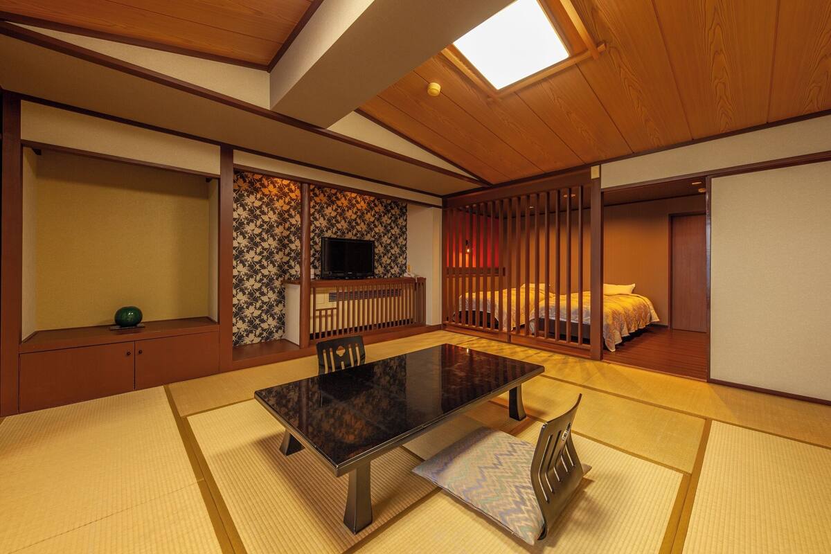 A traditional Japanese room with tatami flooring, a low table, and sliding doors.