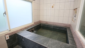 A bathroom with a rectangular hot tub, tiled walls, and a window. - Cyuan Tang Hot Spring Hotel (Jiaoxi)