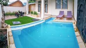 A swimming pool with two purple lounge chairs, a motorcycle, and a well-maintained lawn. - Villa Amidala - Waingapu (Waingapu)