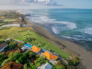 A coastal area with a beach, houses, and a swimming pool. - PNB Beach Resort (Pererenan)