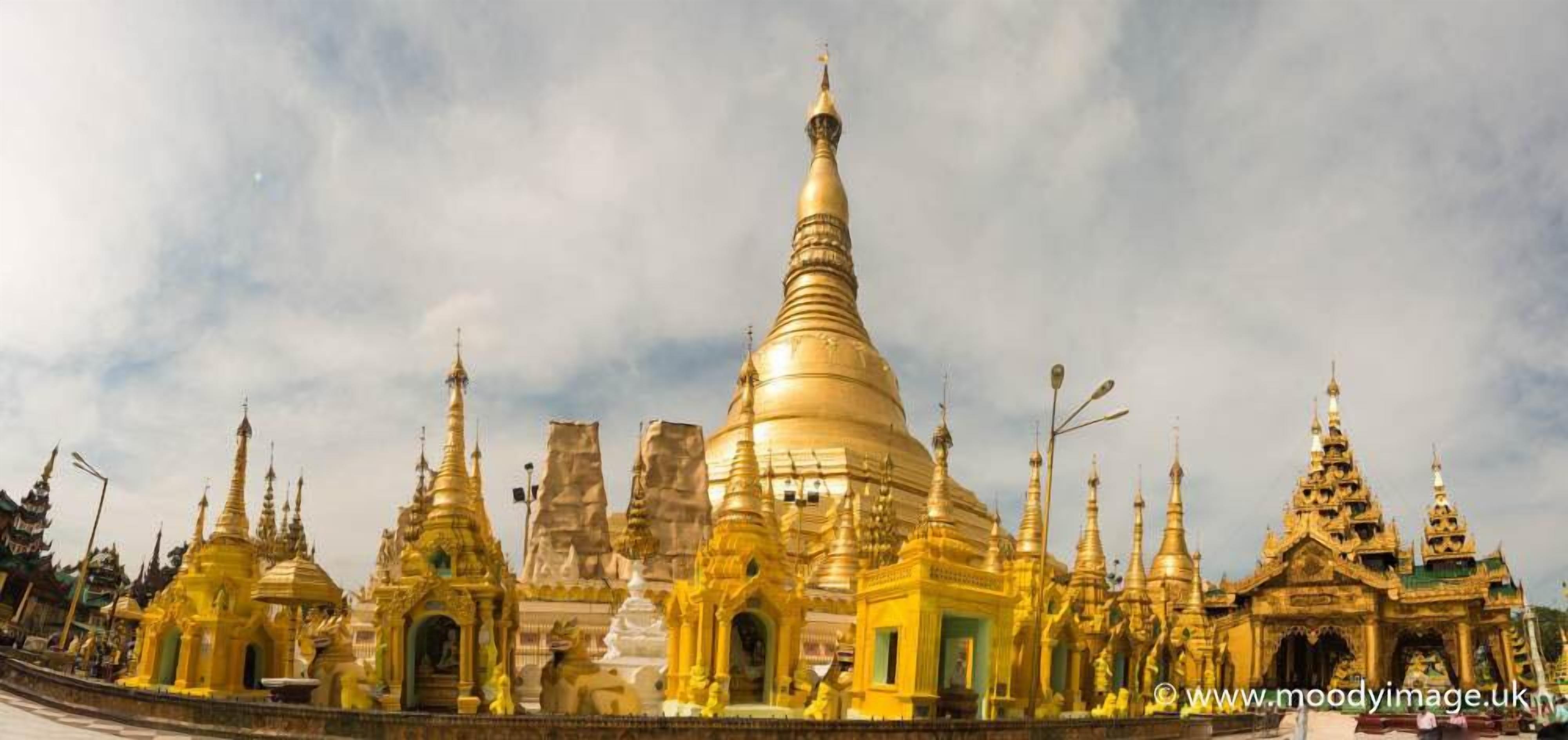 A large golden stupa surrounded by smaller structures, likely part of a temple complex.