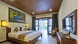 Un dormitorio con una cama de madera, un escritorio y una silla, un cuadro grande en la pared y vistas por la puerta.