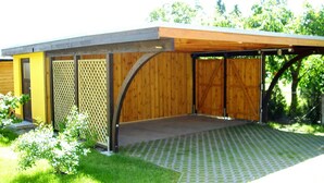 A covered outdoor area with a wooden deck and a fenced patio.