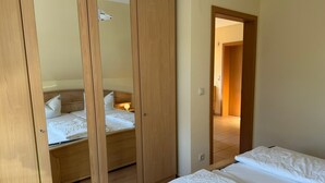 A bedroom with a bed, a wardrobe, and a mirror. - Vacation apartment 3 - Holiday home Karsten (Karlshagen)