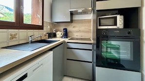 A modern kitchen with a built-in microwave, oven, and coffee maker.
