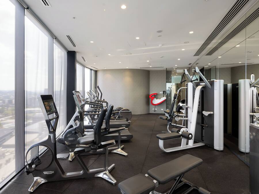 Un gimnasio moderno con cintas de correr, elípticas y equipo de pesas.