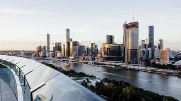 Un moderno horizonte urbano con rascacielos, un río y un puente.