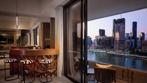 Una habitación de hotel moderna con vistas a la ciudad, una zona de bar y un comedor.