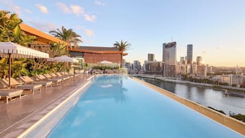 Una piscina al aire libre, sillones reclinables de piscina