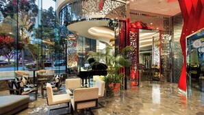 Un vestíbulo moderno con un piano, zona de estar y elementos decorativos.