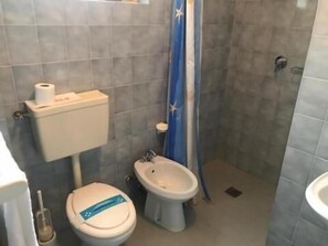 A small bathroom with a toilet, bidet, and a shower curtain. - Hotel Myriam (Lignano Sabbiadoro)